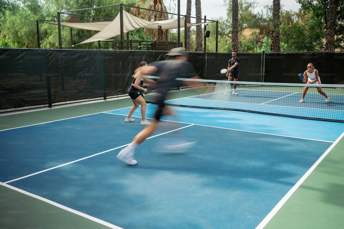 Group of pickleball players celebrating on an outdoor court during a trip